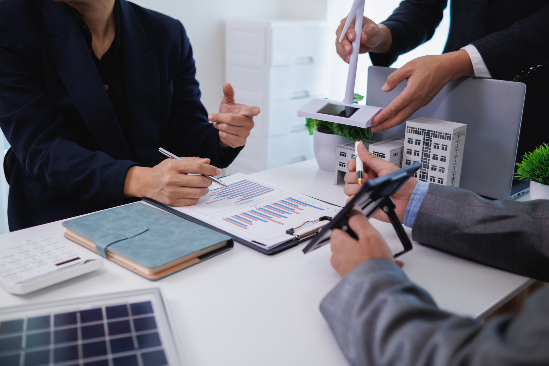 architects and investors discuss real estate projects using clean energy or solar cells within residential construction projects. Concept using clean energy in large residential construction projects.